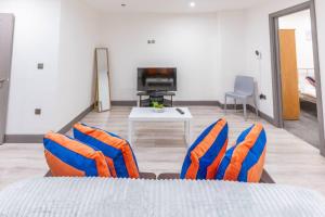 a bedroom with blue and orange chairs and a table at Cosy 2 Bedroom Flat in Bradford, on street parking in Bradford