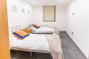 two beds in a room with white walls at Cosy 2 Bedroom Flat in Bradford, on street parking in Bradford