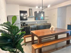 a kitchen with a wooden table and a wooden bench at Apartment Tendenza Centro in Playa del Carmen