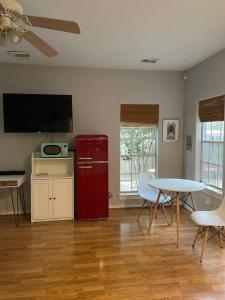 a living room with a red refrigerator and a table at Stylish Studio in Montrose - The Italian Plaza in Houston