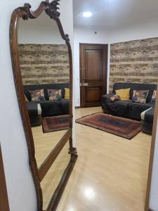 a mirror in a living room with a couch at Happy Guest Apartments - Central Living Borno in Borno
