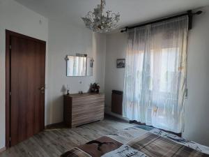 a bedroom with a bed and a dresser and a chandelier at Happy Guest Apartments - Central Living Borno in Borno