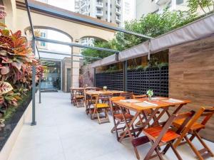 an outdoor patio with wooden tables and chairs at Flat Funchal JK Limpeza Diária, Internet 300mb in Sao Paulo