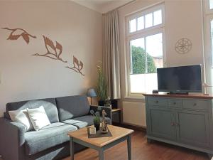 uma sala de estar com um sofá e uma televisão em Apartmenthaus Strandstraße 16 em Kühlungsborn