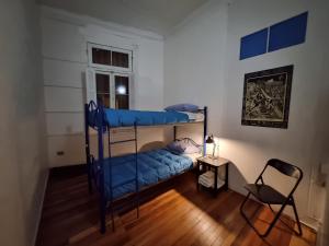 um quarto com 2 beliches e uma cadeira em Escarabajo Hostel em Valparaíso