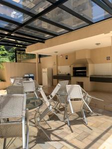 un patio con sillas y una mesa y una cocina en O Lugar! Apto no The Place, en São José dos Campos
