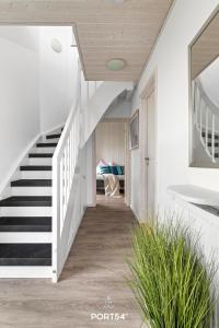 a staircase in a house with white walls and white stairs at Ferienhaus Möwennest Marina Wendtorf in Wendtorf