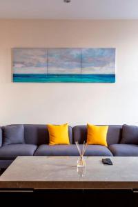 ein Wohnzimmer mit einem blauen Sofa und gelben Kissen in der Unterkunft BOURNECOAST: FLAT - CLOSE TO SHOPS & TOWN - FM6290 in Bournemouth