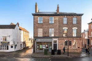 an old brick building with a store in a street at Pass the Keys Luxurious Duplex with Parking in York