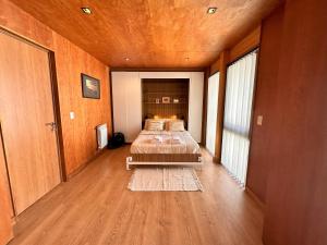 Habitación con 2 camas, paredes de madera y suelo de madera. en Hermoso 2 ambientes, céntrico, 4 pax, muy cálido y cómodo 18V4 en San Martín de los Andes