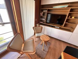 sala de estar con 2 sillas y TV en Hermoso 2 ambientes, céntrico, 4 pax, muy cálido y cómodo 18V4 en San Martín de los Andes