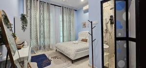 - une chambre avec des murs bleus, un lit et une douche dans l'établissement Glamstay BatuRakit by Beach (Netflix,Umt,Unisza,Ipg), à Kuala Terengganu