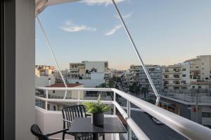 einen Balkon mit einem Tisch und Stühlen sowie Stadtblick in der Unterkunft The Green Penthouse in Iraklio