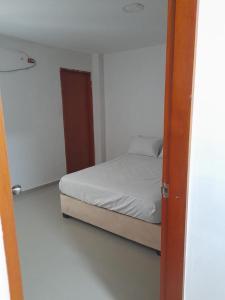 1 dormitorio con 1 cama en una habitación blanca en Casa Campestre JO, en Polonuevo