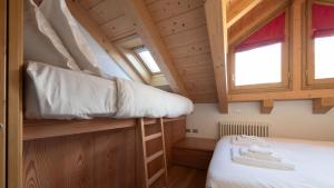 a small room with a bunk bed and two windows at Italianway - Osteglio 15 F - Viola in Valdisotto
