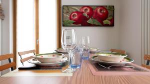 a dining room table with plates and glasses and a picture of apples at Italianway - Osteglio 15 F - Viola in Valdisotto
