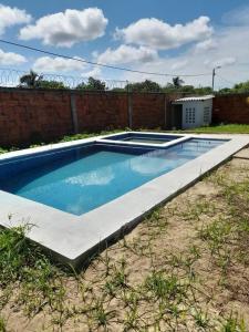 a swimming pool in a yard next to a brick wall at Casa Campestre JO in Polonuevo