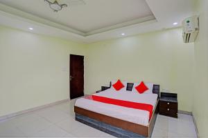 a bedroom with a large bed with red pillows at OYO Flagship Shree Shyam Kripa Hotel And Restaurant in Kānpur