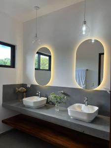 two sinks in a bathroom with two mirrors at Solemar 2bdrm House - Private Pool , King Bed and Balcony Sunset View in Mal País