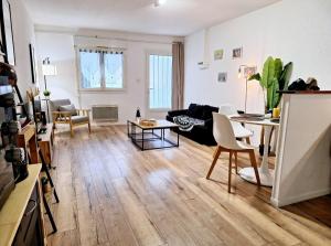 ein Wohnzimmer mit einem Sofa und einem Tisch in der Unterkunft Appartement Cosy Proche Gare - Fibre Optique et Parking in Angoulême