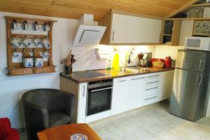 uma cozinha com armários brancos e um frigorífico de aço inoxidável em Ferienhaus Manoury am Klosterbrunnen em Waldeck