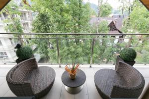 two chairs and a table on a balcony with a window at VIP Apartamenty Stara Polana in Zakopane +152 photos