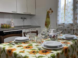 a kitchen with a table with plates and wine glasses at A Casa di Luca in Faenza