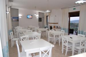 een eetkamer met witte tafels en witte stoelen bij Case vacanze NIOLEO - Apartments and Pool in Siniscola