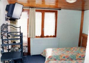 a bedroom with a bed and a tv and a window at Le Sestriere in La Foux