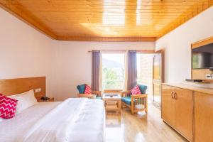 Aroha Residency- A Countryside Resort في مانالي: غرفة نوم بسرير وطاولة وكراسي