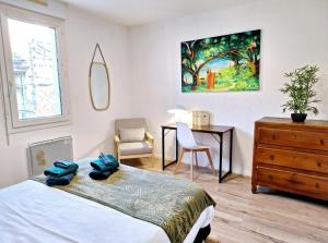 Schlafzimmer mit einem Bett, einem Schreibtisch und einer Kommode in der Unterkunft Appartement Cosy Proche Gare - Fibre Optique et Parking in Angoulême