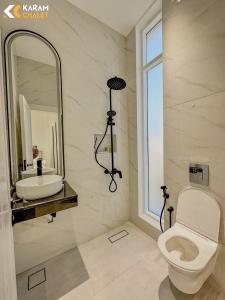 uma casa de banho com um WC, um lavatório e um espelho. em كرم شاليه em Barka