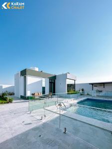 uma villa com uma piscina e uma casa em كرم شاليه em Barka