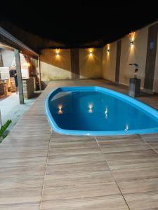 een groot blauw zwembad op een patio bij Casa de Praia Mongaguá in Mongaguá