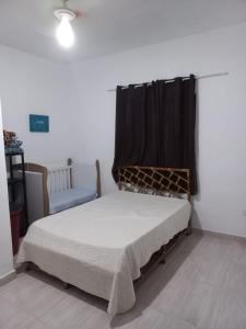 een slaapkamer met een bed met een zwart gordijn bij Casa de Praia Mongaguá in Mongaguá