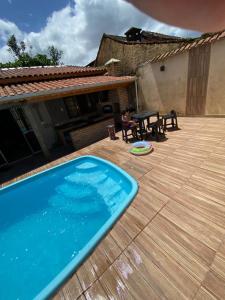 een zwembad op een houten terras naast een huis bij Casa de Praia Mongaguá in Mongaguá