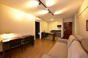 ein Wohnzimmer mit einem Sofa und einem Tisch in der Unterkunft Golden Tulip Goiania Address in Goiânia