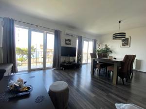 a living room with a dining room table and a dining room at Black and White Apartment - 2 bedrooms, walk to the beach in Duće