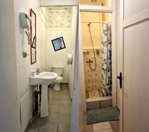 y baño con lavabo, aseo y ducha. en Escarabajo Hostel en Valparaíso