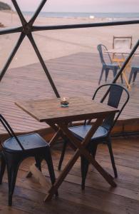 a wooden table and two chairs on a deck at Domos Park in Mar de las Pampas