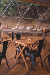 a large wooden table and chairs in a tent at Domos Park in Mar de las Pampas