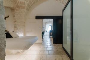 - une chambre avec un lit dans un mur en pierre dans l'établissement Rifugio del Monsignore, à Ostuni