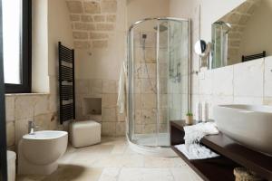 uma casa de banho com um chuveiro, um lavatório e um WC. em Rifugio del Monsignore em Ostuni