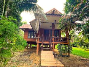 a house with a porch and stairs in front of it at Koh Yao Noi Garden Home in Ban Nai Khlong