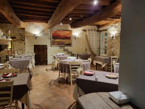 ein Restaurant mit Tischen und Stühlen in einem Zimmer in der Unterkunft Logis Hotel Restaurant la Ferme in Avignon