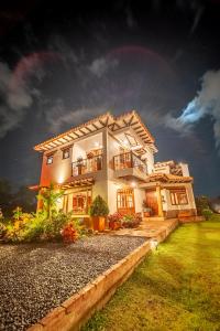une grande maison avec une pelouse devant elle dans l'établissement Casa de las Flores, à Villa de Leyva