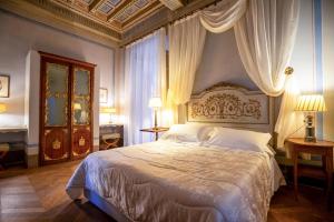 ein Schlafzimmer mit einem großen Bett mit Vorhängen darauf in der Unterkunft Palazzo Rocchi B&B in Lucca