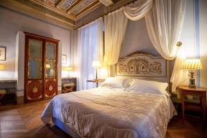 a bedroom with a large bed with curtains on it at Palazzo Rocchi B&B in Lucca