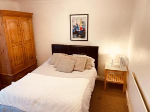 a bedroom with a bed with white sheets and pillows at Aston Henry James William Street Close to Reading Town Centre in Reading