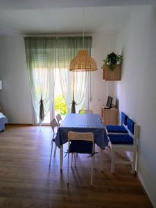 a dining room with a blue table and chairs and a window at Trilo Lorenzo - In centro ed a soli 30 m dal mare in Numana